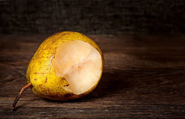 Una pera morsa sdraiata su un tavolo di legno — Foto Stock