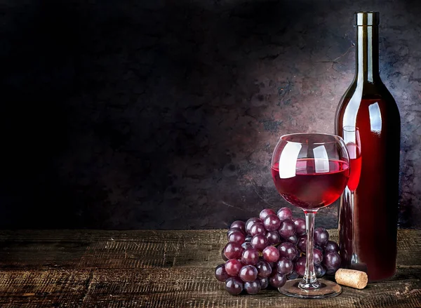 Glass of red wine with grapes and bottle Royalty Free Stock Images