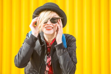 Mutlu genç kadın parlak sarı duvarın üzerinden