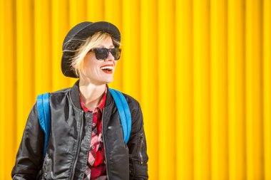 Mutlu genç kadın parlak sarı duvarın üzerinden