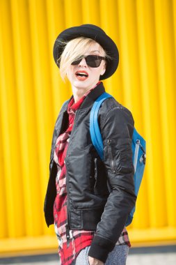 Mutlu genç kadın parlak sarı duvarın üzerinden