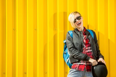 Mutlu genç kadın parlak sarı duvarın üzerinden