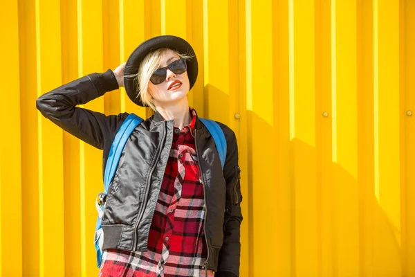 Gelukkig jonge vrouw over heldere gele muur — Stockfoto