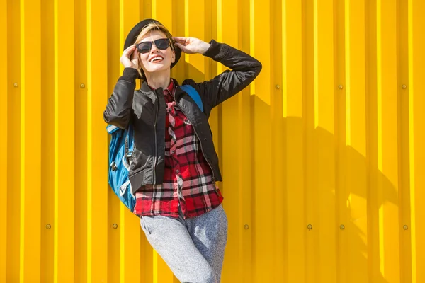 Gelukkig jonge vrouw over heldere gele muur — Stockfoto