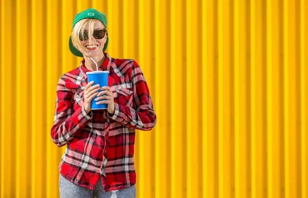 Gelukkig jonge vrouw over heldere gele muur — Stockfoto