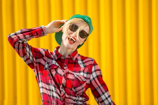 Happy young woman over bright yellow wall — Stock Photo, Image