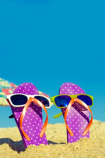 Flip komik çift sunglassen ile sahilde floplar. — Stok fotoğraf