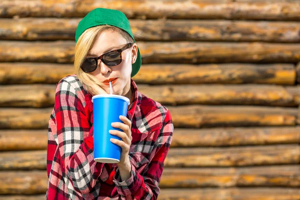 Vacker ung kvinna i hatt mössa dricka cola — Stockfoto