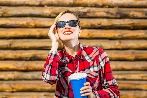 Krásná mladá žena v klobouku víčko pití cola — Stock fotografie