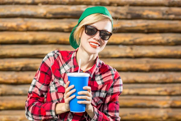 Mooie jonge vrouw in hoed GLB drinken cola — Stockfoto