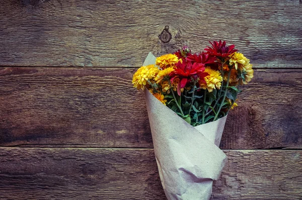 Autumn flowers on a grungwe wooden background — Stockfoto