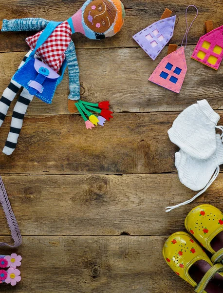 Смешные игрушки, детская обувь на деревянном фоне — стоковое фото