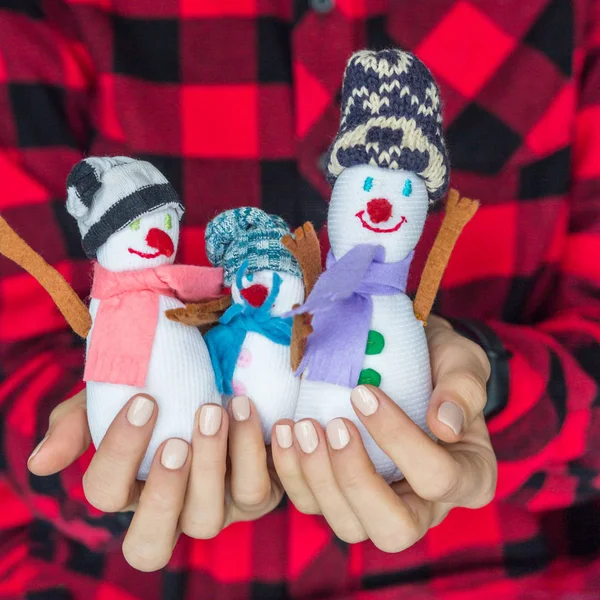 Petits bonhommes de neige dans les mains des femmes — Photo