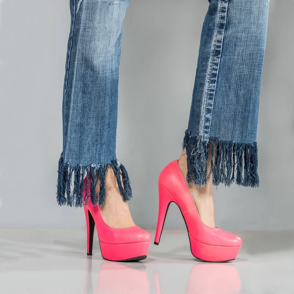 Fröhliche junge Frau mit sexy Beinen in Jeans und High Heels — Stockfoto
