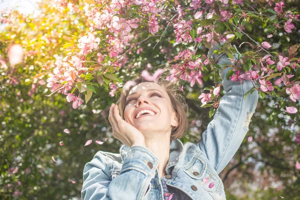 Молодая счастливая женщина улыбается, наслаждаясь весенним летним днем — стоковое фото