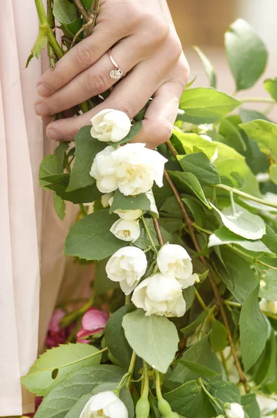Άνοιξη εμπλοκή γυναίκα χέρι με ένα δαχτυλίδι και άνοιξη λουλούδια — Φωτογραφία Αρχείου