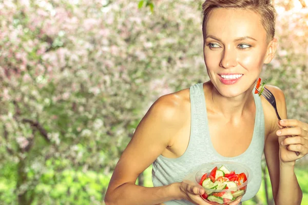 Kvinna äta hälsosam sallad från plastbehållare utomhus på s solig sommardag — Stockfoto