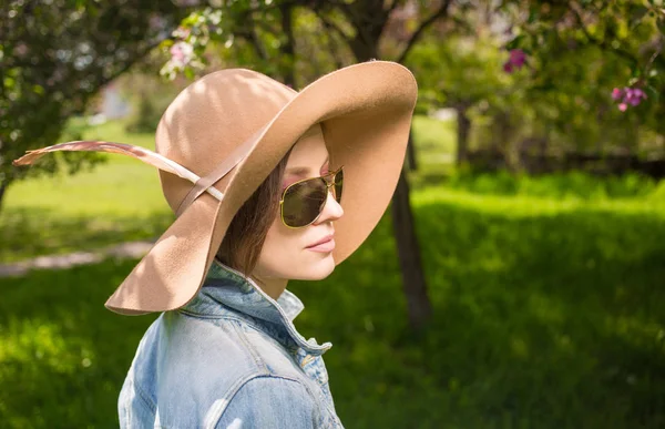 Młoda kobieta w park portret na sobie czapkę z piór — Zdjęcie stockowe