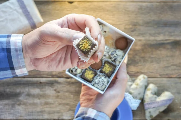 Doces de chocolate na mão do homem — Fotografia de Stock