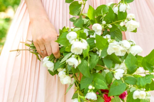 Νεαρή γυναίκα χέρι με λουλούδια και όμορφο δαχτυλίδι — Φωτογραφία Αρχείου