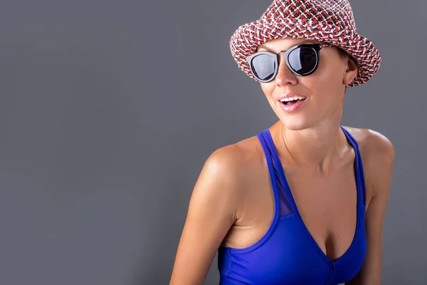 Chica juguetona en sombrero y gafas de sol con traje de neopreno — Foto de Stock