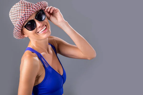Playful girl in hat and sunglasses wearing swisuit — Stock Photo, Image