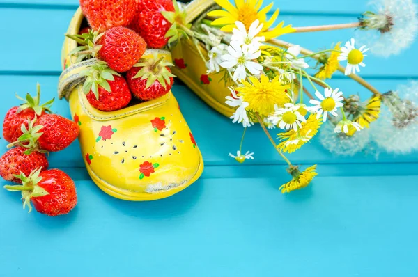 Sommer Hintergrund mit Erdbeeren und winzigen Babyschuhen — Stockfoto