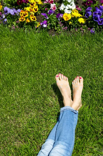 เท้าของผู้หญิงบนหญ้า เท้าเปล่า — ภาพถ่ายสต็อก