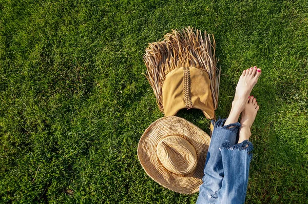 Descalço pernas femininas sentado na grama verde — Fotografia de Stock