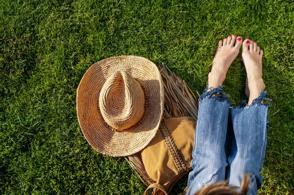 Descalço pernas femininas sentado na grama verde — Fotografia de Stock