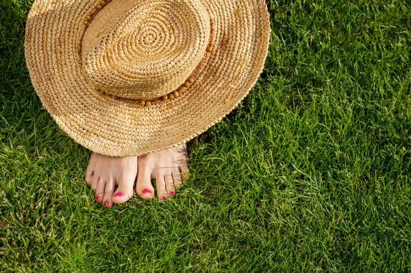 Girls ben liggande i gräset barfota utan skor — Stockfoto