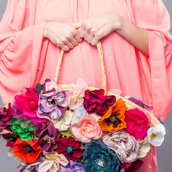 Beautiful woman in pink dress holding floral bag isolated over grey — Stock Photo, Image