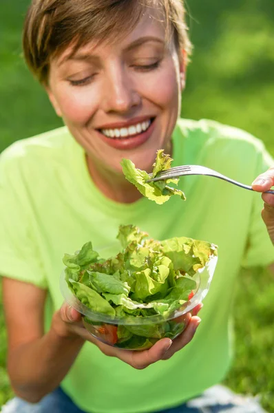 Πορτρέτο της ελκυστικής καυκάσιας χαμογελαστή γυναίκα τρώει σαλάτα — Φωτογραφία Αρχείου