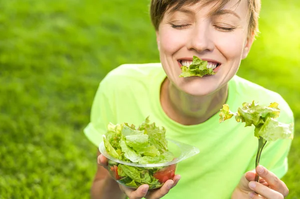 Porträt einer attraktiven kaukasischen lächelnden Frau beim Salatessen — Stockfoto