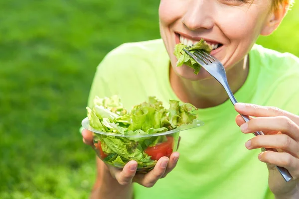 Mujer almorzando descansando relajándose al aire libre sentada sobre hierba verde — Foto de Stock