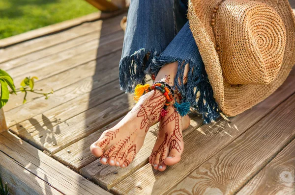 Beautiful legs of young woman wearing jeans, beads accessories — Stock Photo, Image