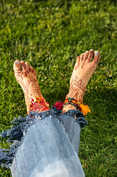 Close-up van vrouwelijke benen met accessoires en mehendi — Stockfoto