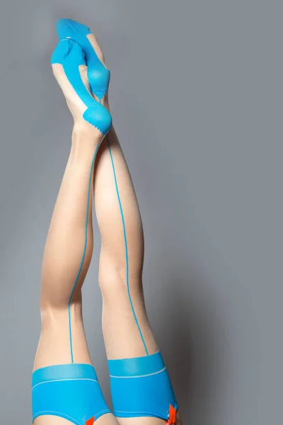 Lencería, medias. Hermosas piernas largas mujer usando medias azules y marrones — Foto de Stock