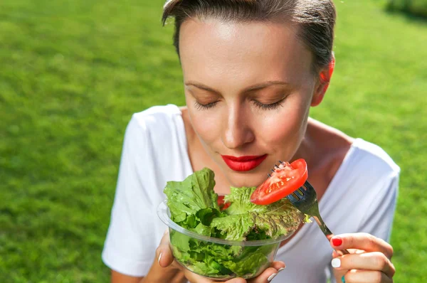 Retrato de atractiva mujer caucásica sonriente comiendo ensalada — Foto de Stock