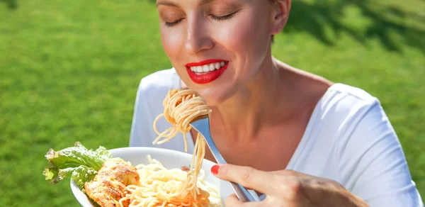 Young brunette woman eating spaghetti