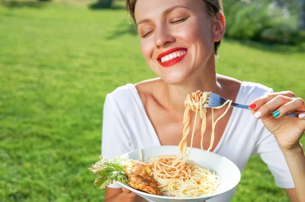 Young brunette woman eating spaghetti