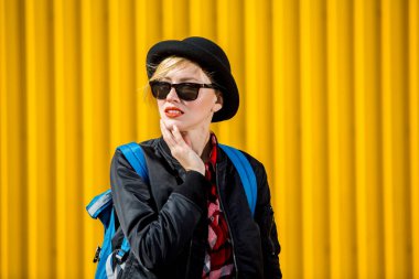 Parlak sarı duvar arka plan üzerinde mutlu genç kadın