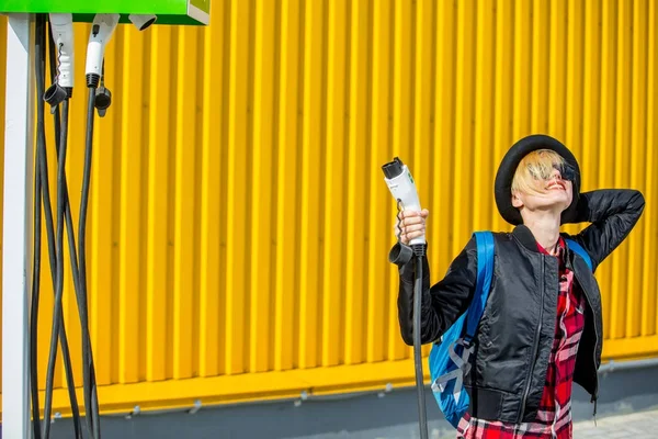 Glückliche Frau lädt Elektroauto an Ladestation — Stockfoto