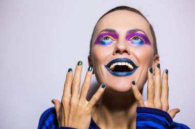 Güzel bir kadınla komik olağandışı makyaj ve manikür.