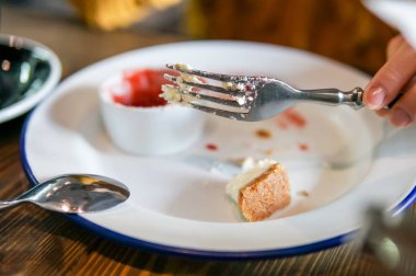 Gümüş çatal ve boş kirli tabak tutan el