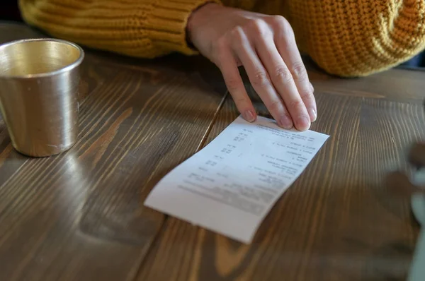 Woman hold a check bill in cafe — Stock Photo, Image