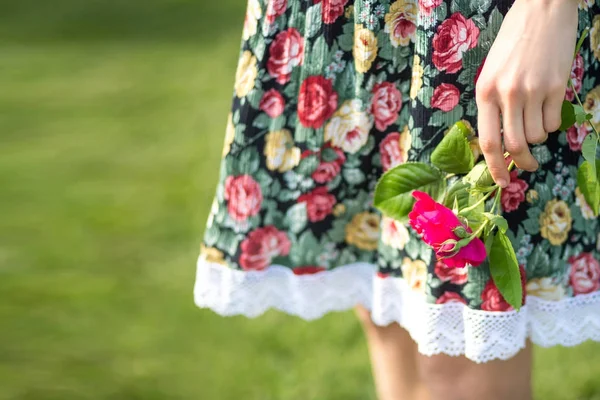 Jovem no vestido segurando uma flor — Fotografia de Stock