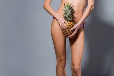 Ananas ile seksi yaz bacaklar. Gıda porno kavramı. En az yaratıcı sanat