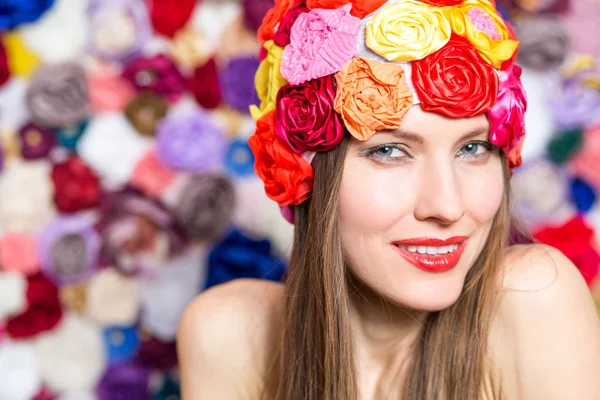 花の背景の上の帽子でかなり若い笑顔の女性 — ストック写真
