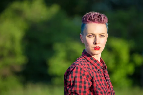 Portrait of a modern girl with bright pink and blue short hairstyle. Outdoors casual portrait. Hair coloring